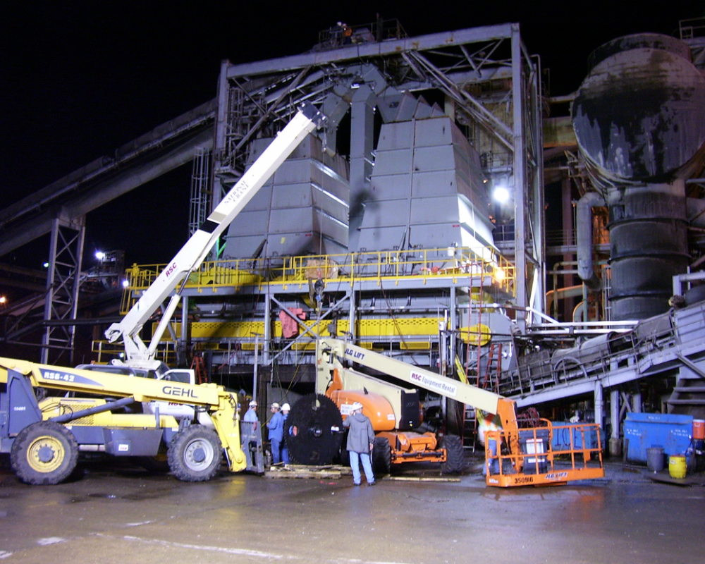 group of men working on a plant's equipment at night