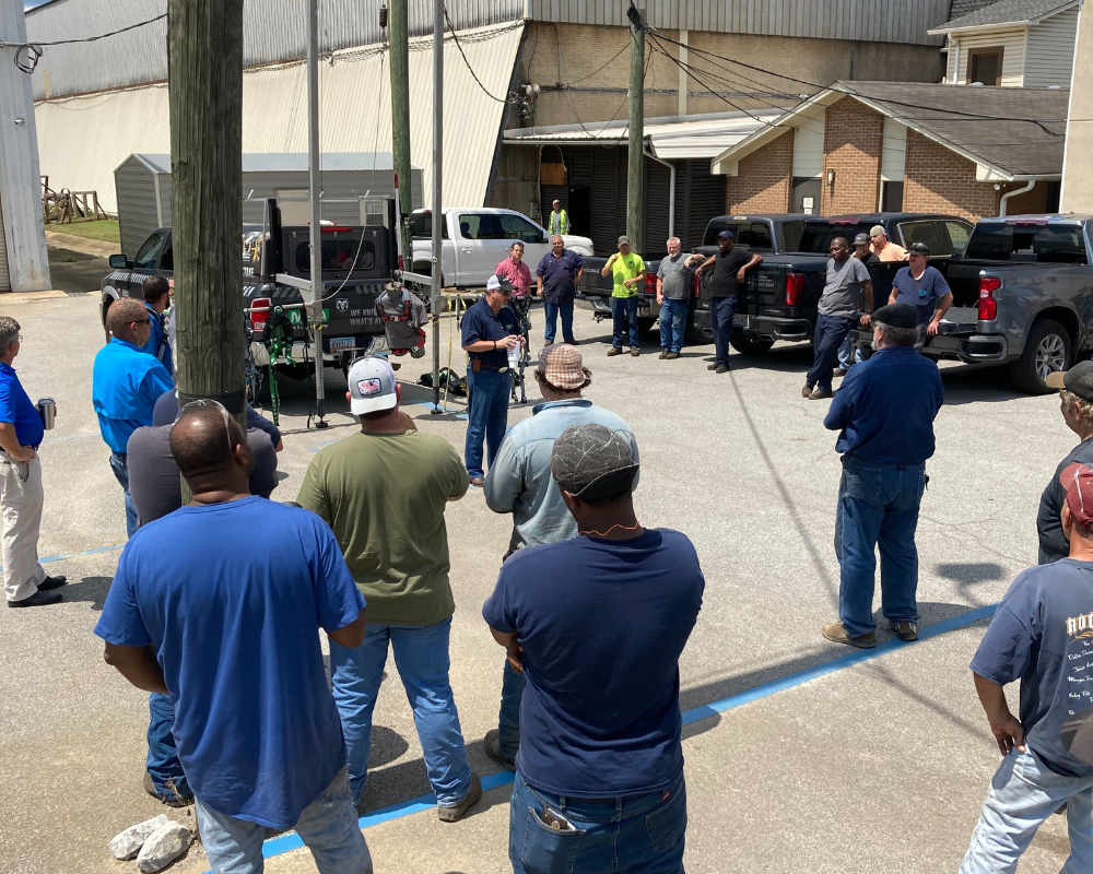group of men standing around a safety demonstration