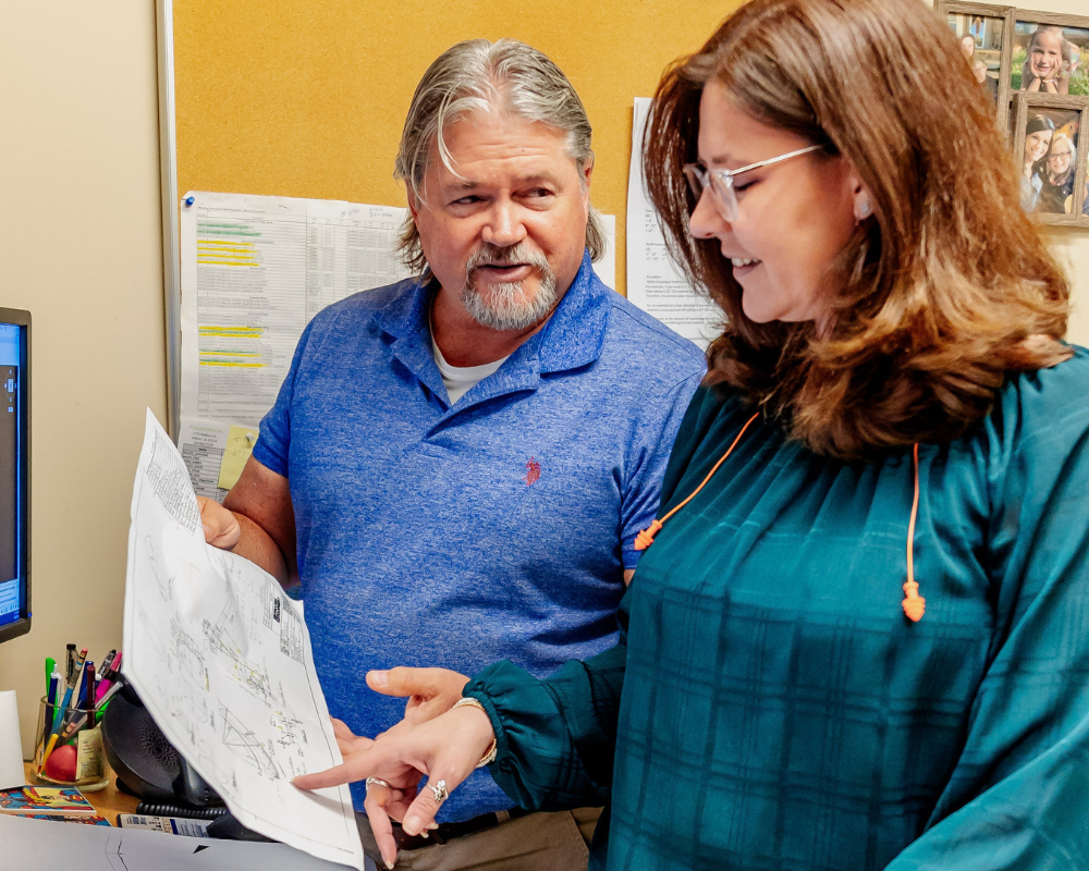 female and male coworker reviewing an equipment drawing